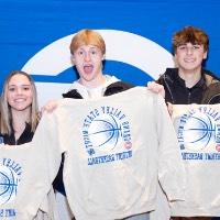 group of 5 people hold up their sweatshirt